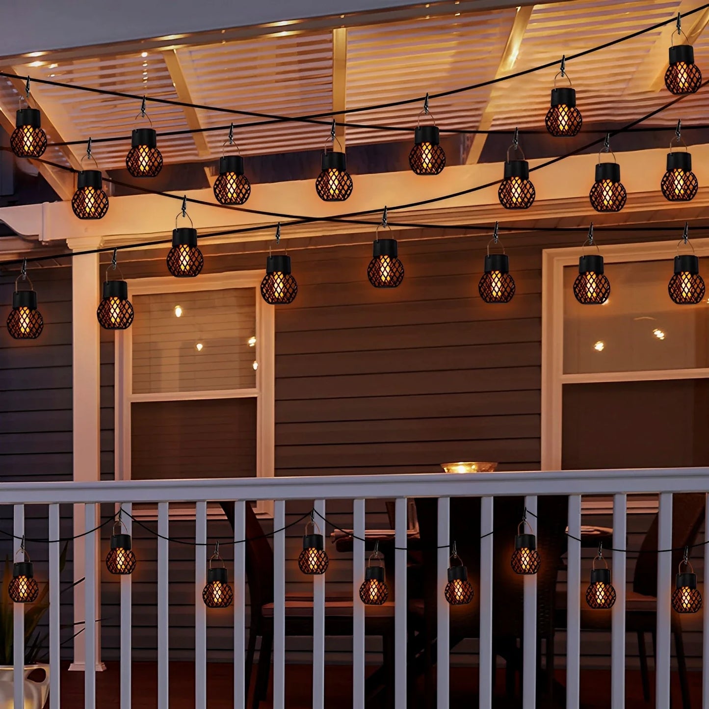 String lights with lantern-style bulbs hanging above a deck at night.