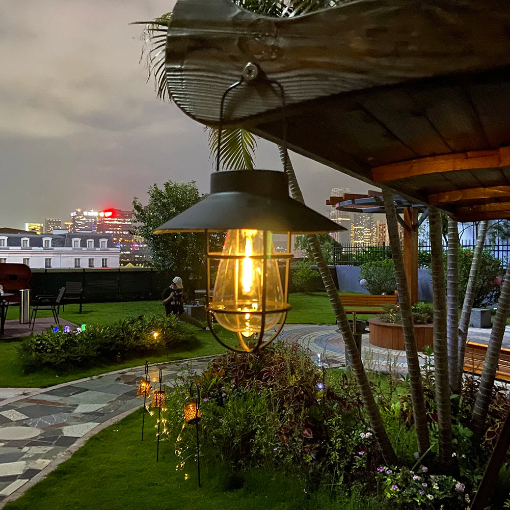 Garden setting with a hanging light fixture and city skyline in the background