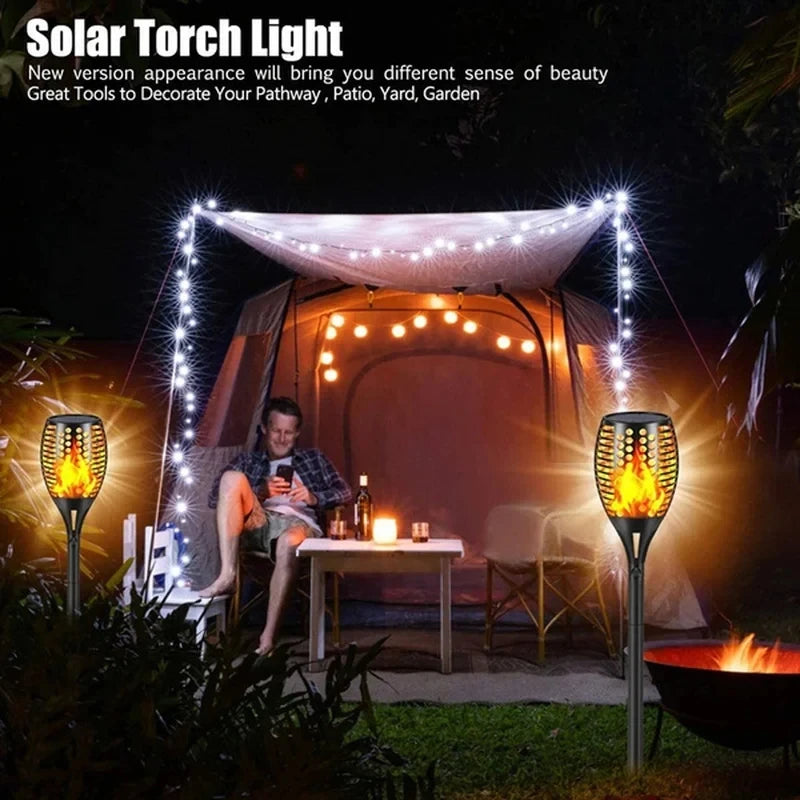 Solar torch lights decorating a patio area with a tent and outdoor furniture.