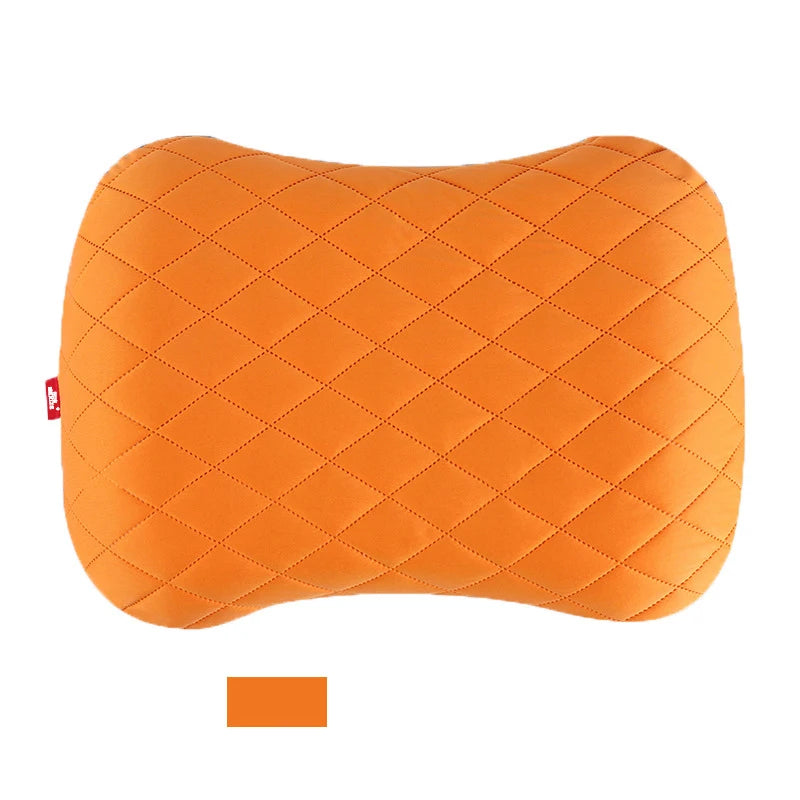 Orange quilted pillow with a small tag on a white background