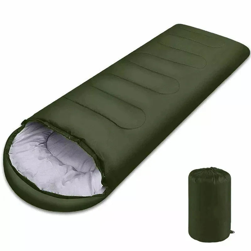 Green sleeping bag with white interior and matching green compression sack on a white background