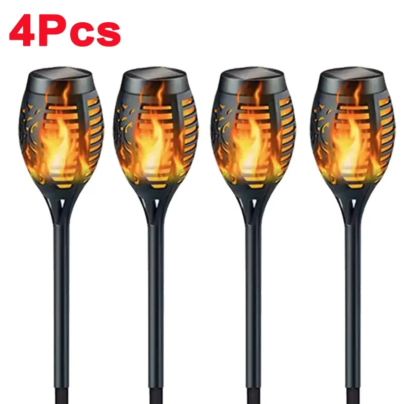 Four solar garden lights with flame design on a white background