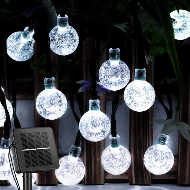 Solar string lights with crystal ball bulbs on a dark background