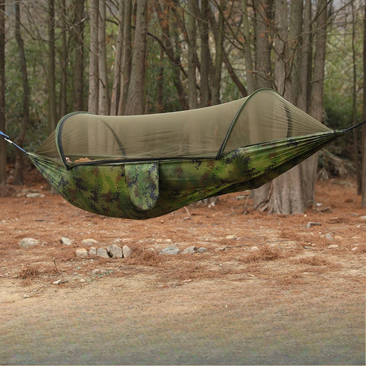 Camouflage hammock with mosquito net in a forest setting