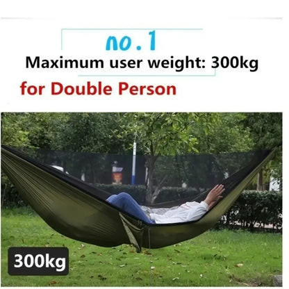 Person lying in a green hammock with text indicating maximum weight capacity on a grassy area.