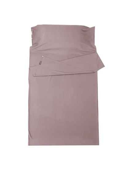 Folded mauve bed sheet set on a white background