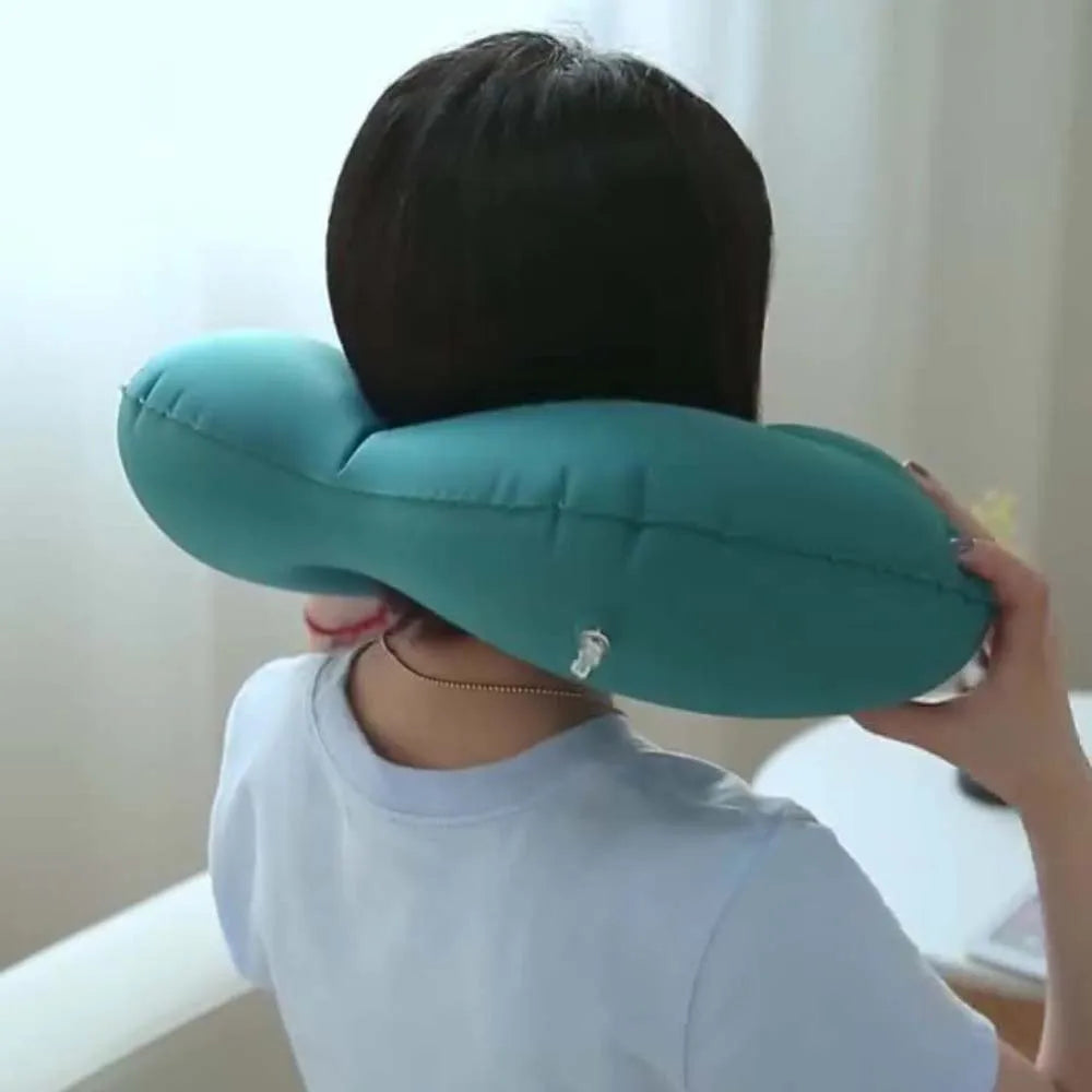 Person using a green neck pillow against a light background