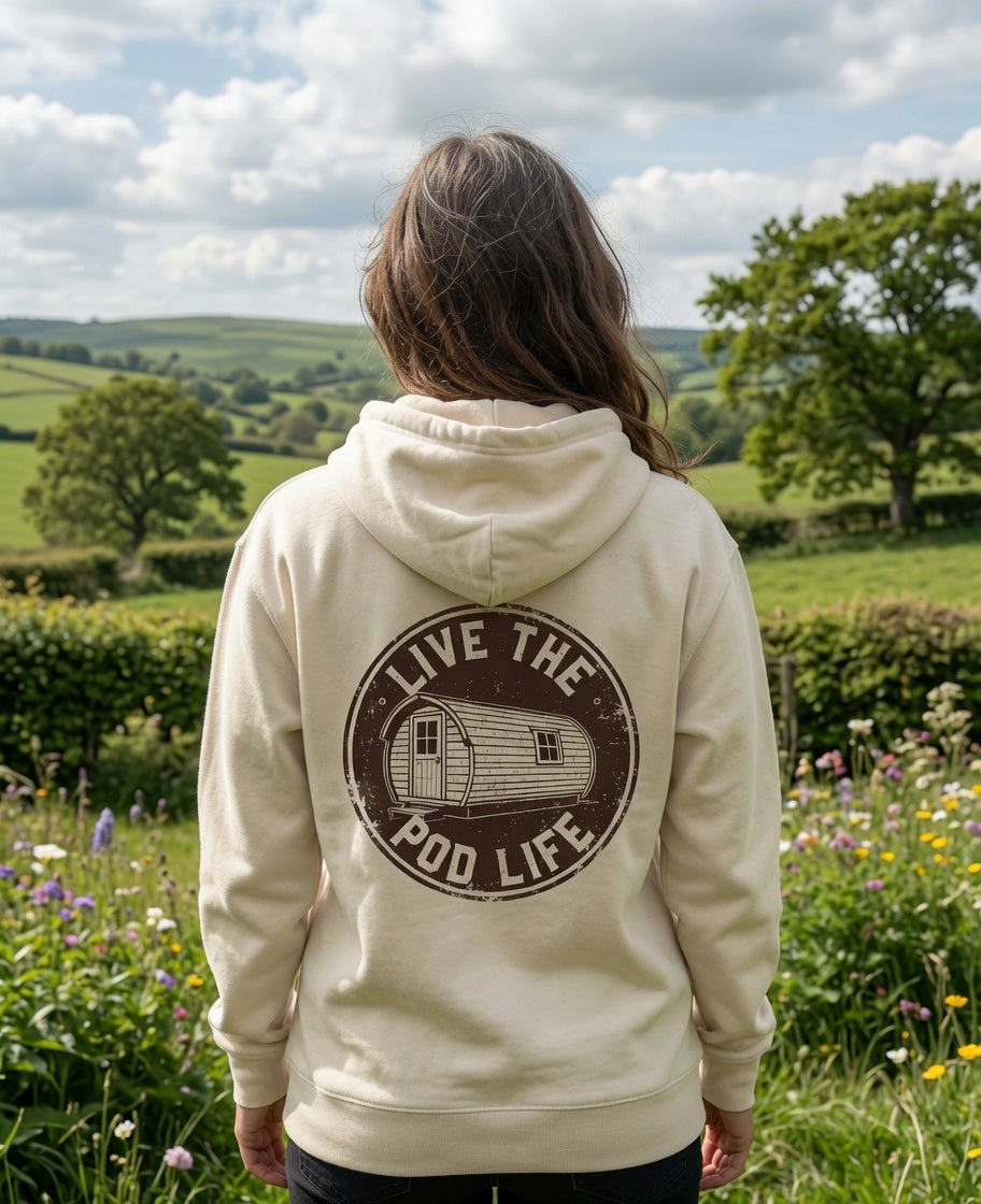 Person wearing a hoodie with 'Live the Pod Life' design in a field